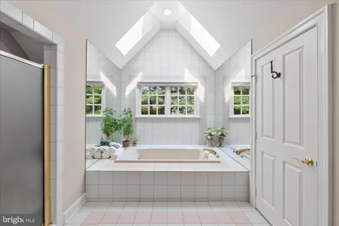 a spacious bathroom with tub and window