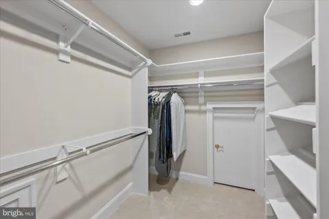 a view of walk in closet with empty racks