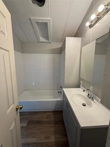 a bathroom with a tub sink and mirror