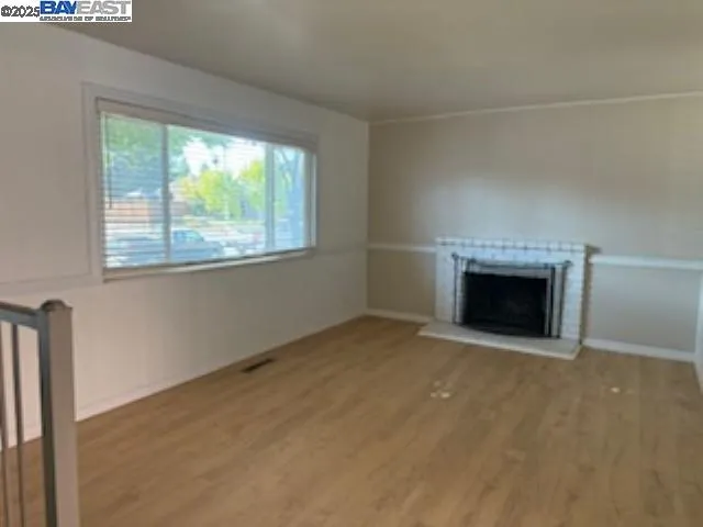 an empty room with a fireplace and a window
