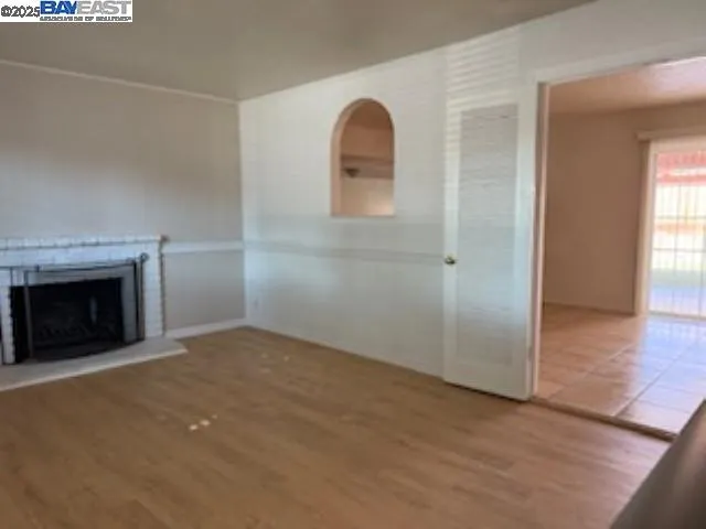 an empty room with windows and fireplace