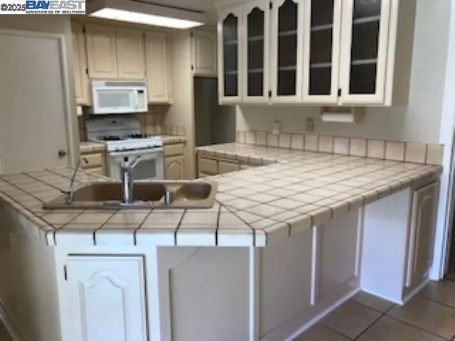 a kitchen with a sink a stove and cabinets