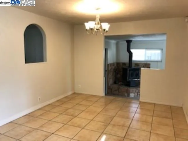 an empty room with windows and a chandelier fan