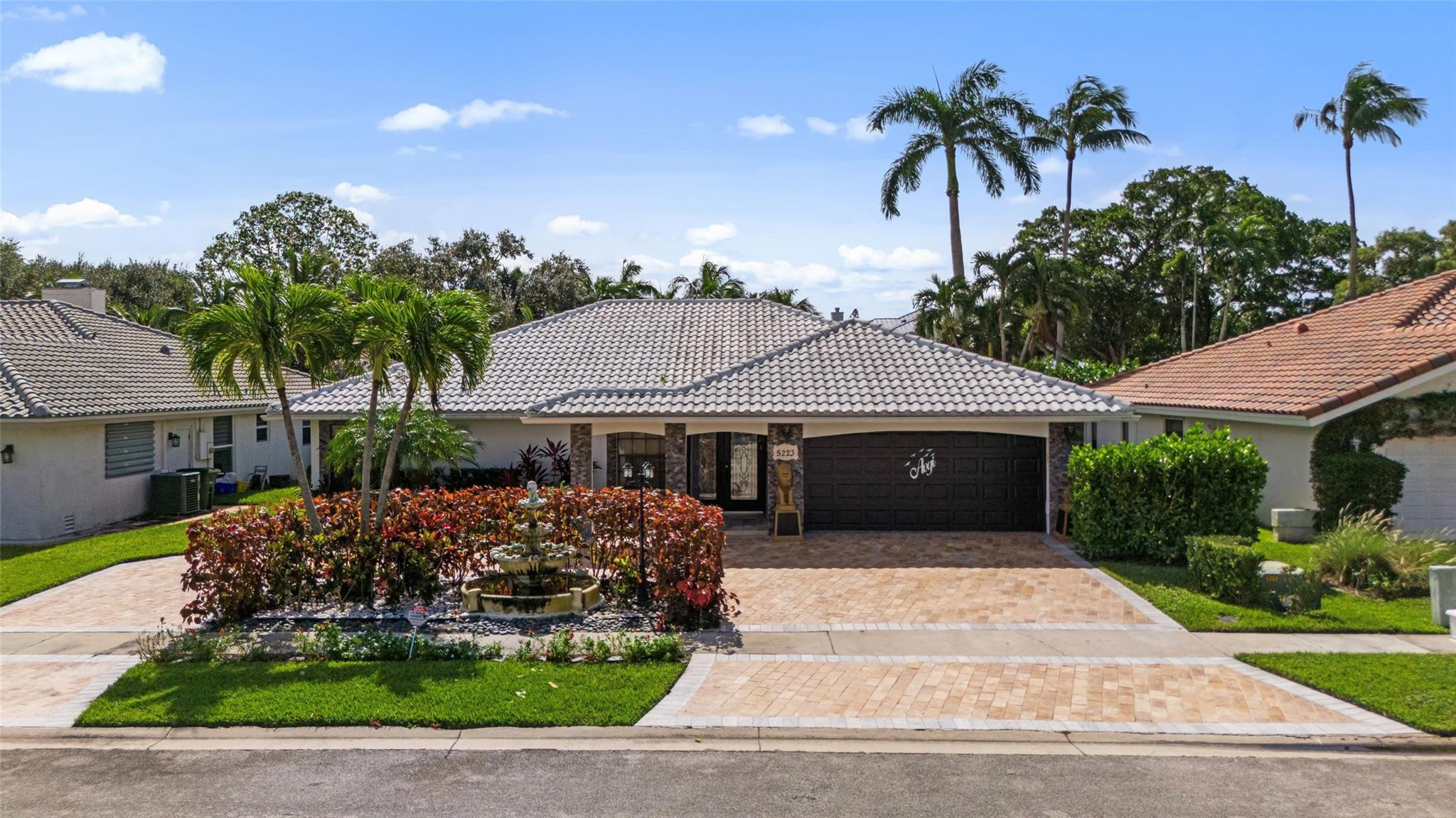 5223 Deerhurst Crescent Circle Boca Raton, FL 33486 - Photo 1 of 51 a front view of a house with a garden and plants