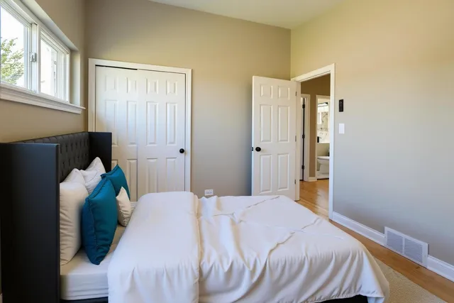 a bedroom with a bed and wooden floor