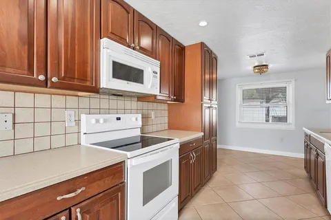 a kitchen with stainless steel appliances granite countertop a stove a sink and a microwave