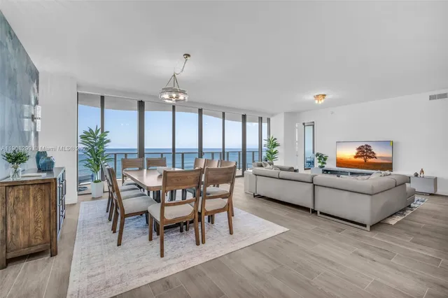 a dining room with furniture a chandelier and wooden floor