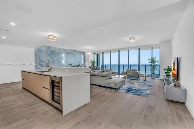 a kitchen with stainless steel appliances kitchen island granite countertop a refrigerator a stove a microwave and island with wooden floor