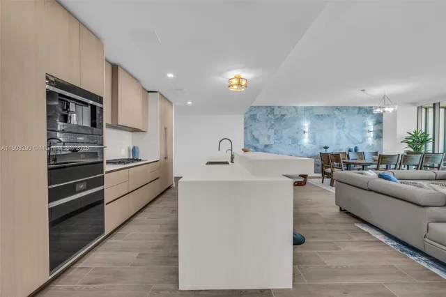 a large kitchen with kitchen island a large window a sink and a counter space