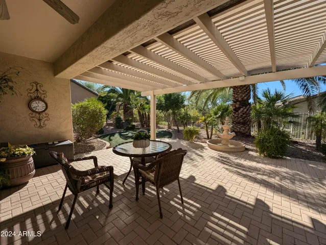 a view of a patio with a table and chairs under an umbrella