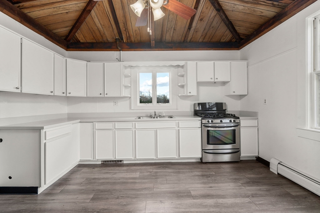 83 Fairhaven Road Mattapoisett, MA 02739 - Photo 14 of 41 a kitchen with stainless steel appliances a stove a sink and white cabinets