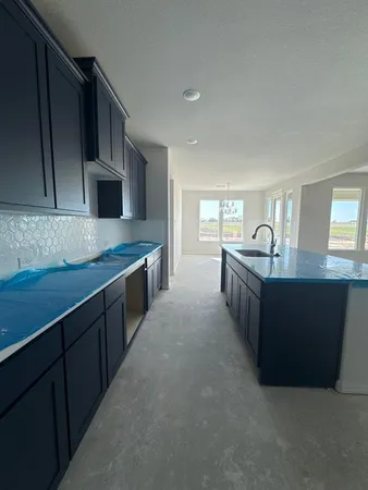 a large kitchen with kitchen island granite countertop a sink and cabinets