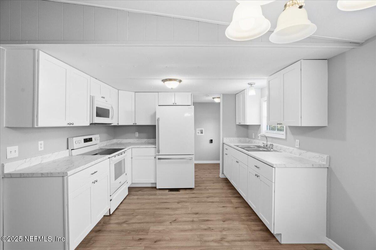 6480 Keith Griffis Circle Macclenny, FL 32063 - Photo 12 of 50 a large white kitchen with a sink and dishwasher refrigerator stove