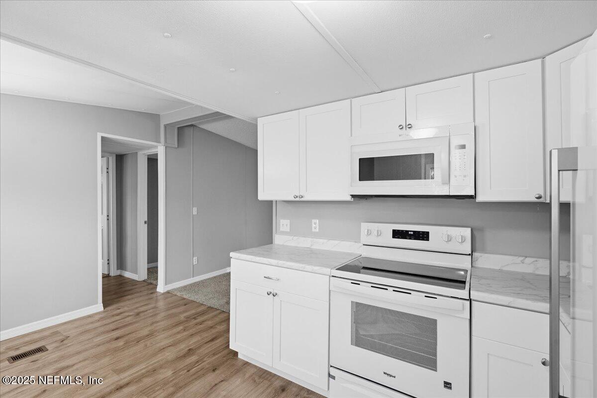 6480 Keith Griffis Circle Macclenny, FL 32063 - Photo 15 of 50 a kitchen with white cabinets stainless steel appliances and sink