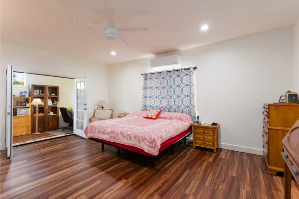 a bedroom with a bed and wooden floor