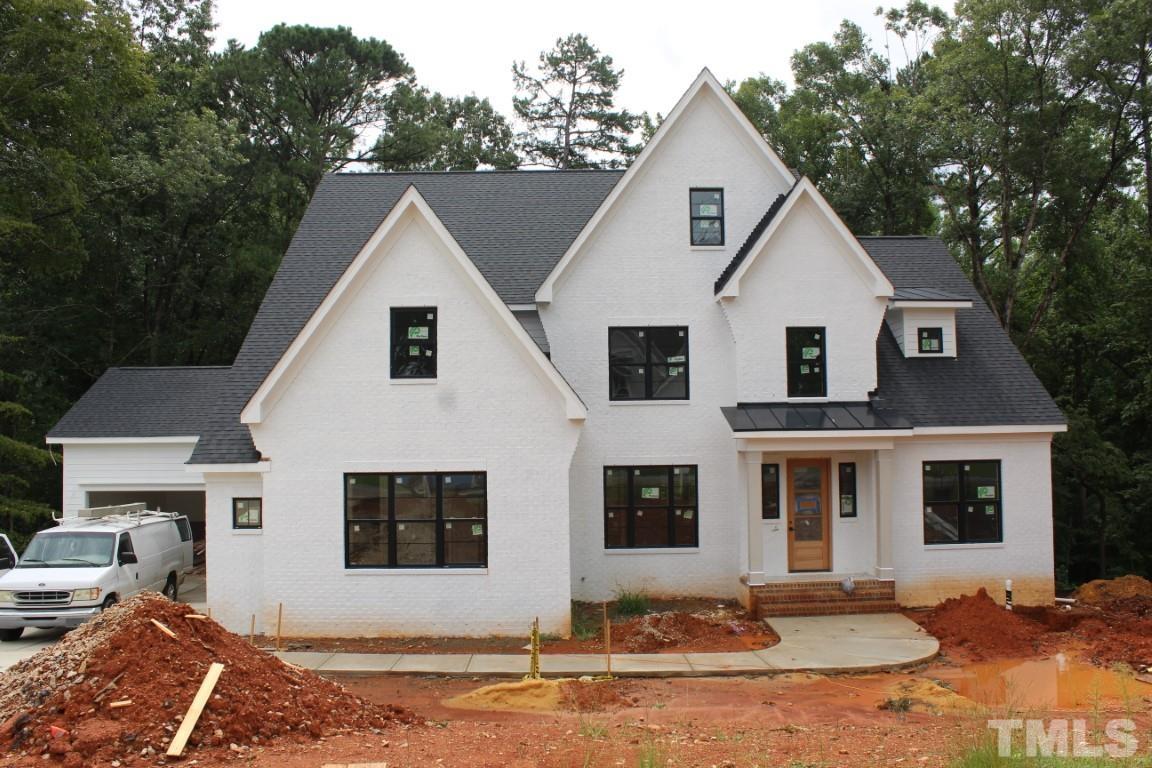 a view of a white house with large windows next to a yard