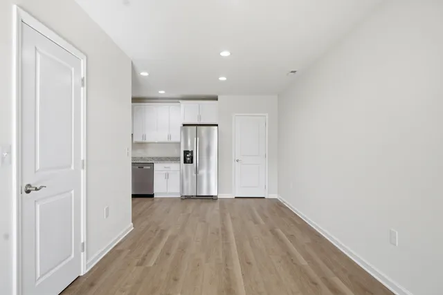 a view of a kitchen with wooden floor and a ceiling fan