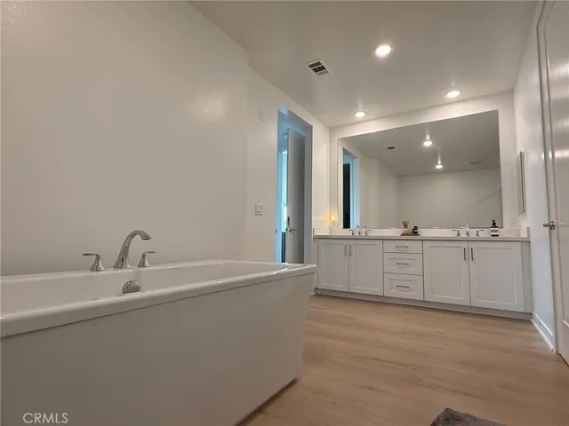 a bathroom with a bathtub sink and mirror