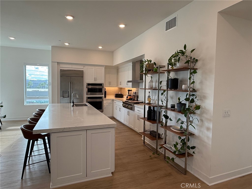 3414 Rivington Irvine, CA 92612 - Photo 4 of 33 a kitchen with kitchen island a stove and a wooden floor