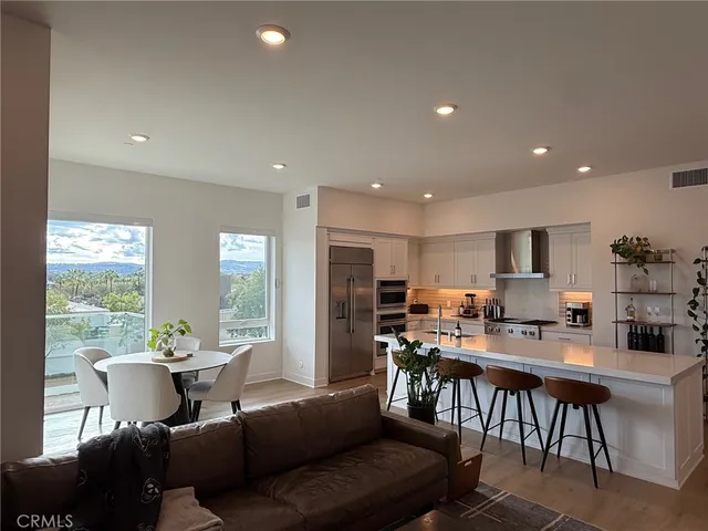 a living room with stainless steel appliances kitchen island granite countertop furniture and a large window