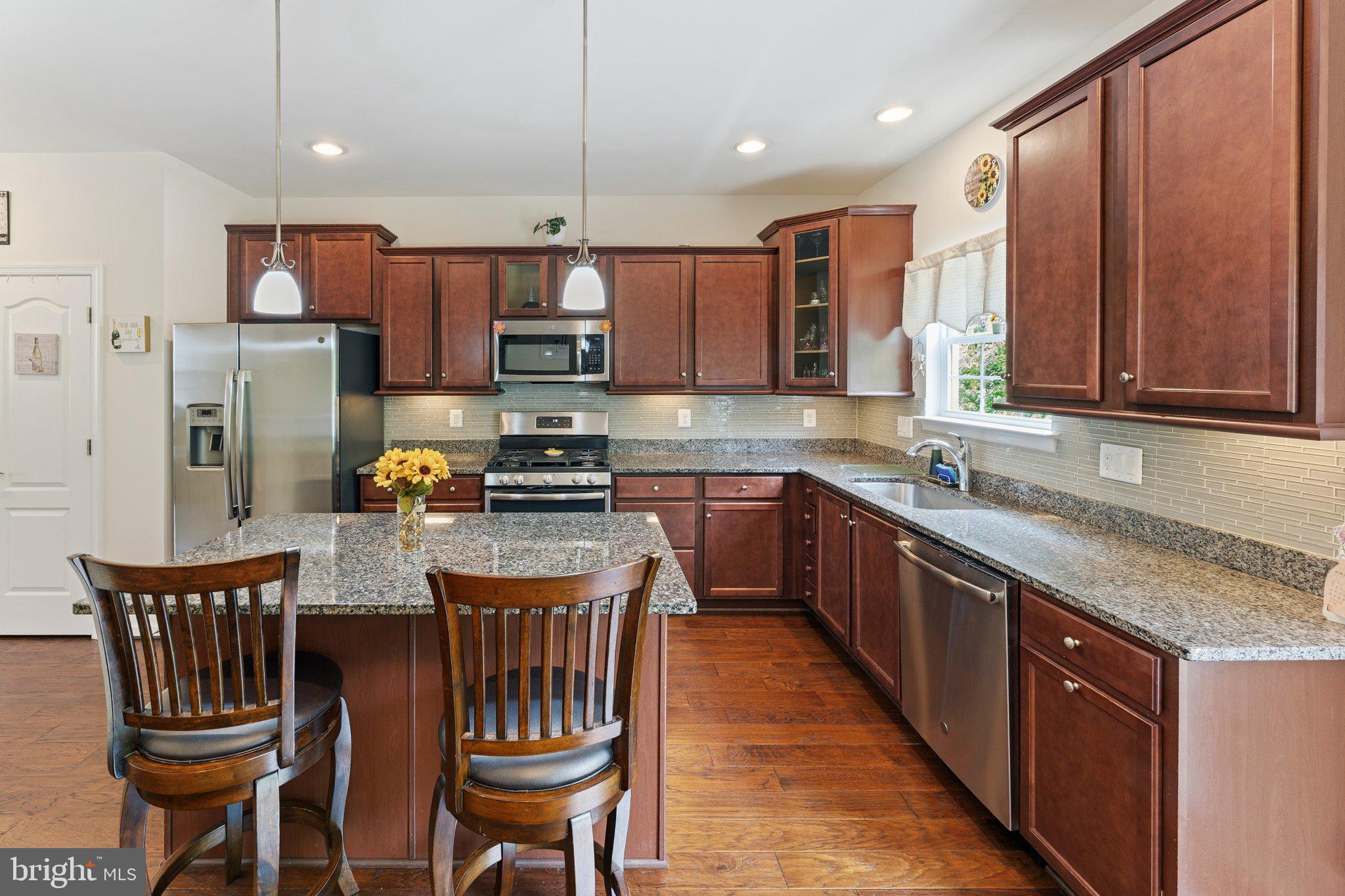 320 Tree Line Drive Fredericksburg, VA 22405 - Photo 15 of 49 a kitchen with stainless steel appliances granite countertop a kitchen island a stove a table and chairs