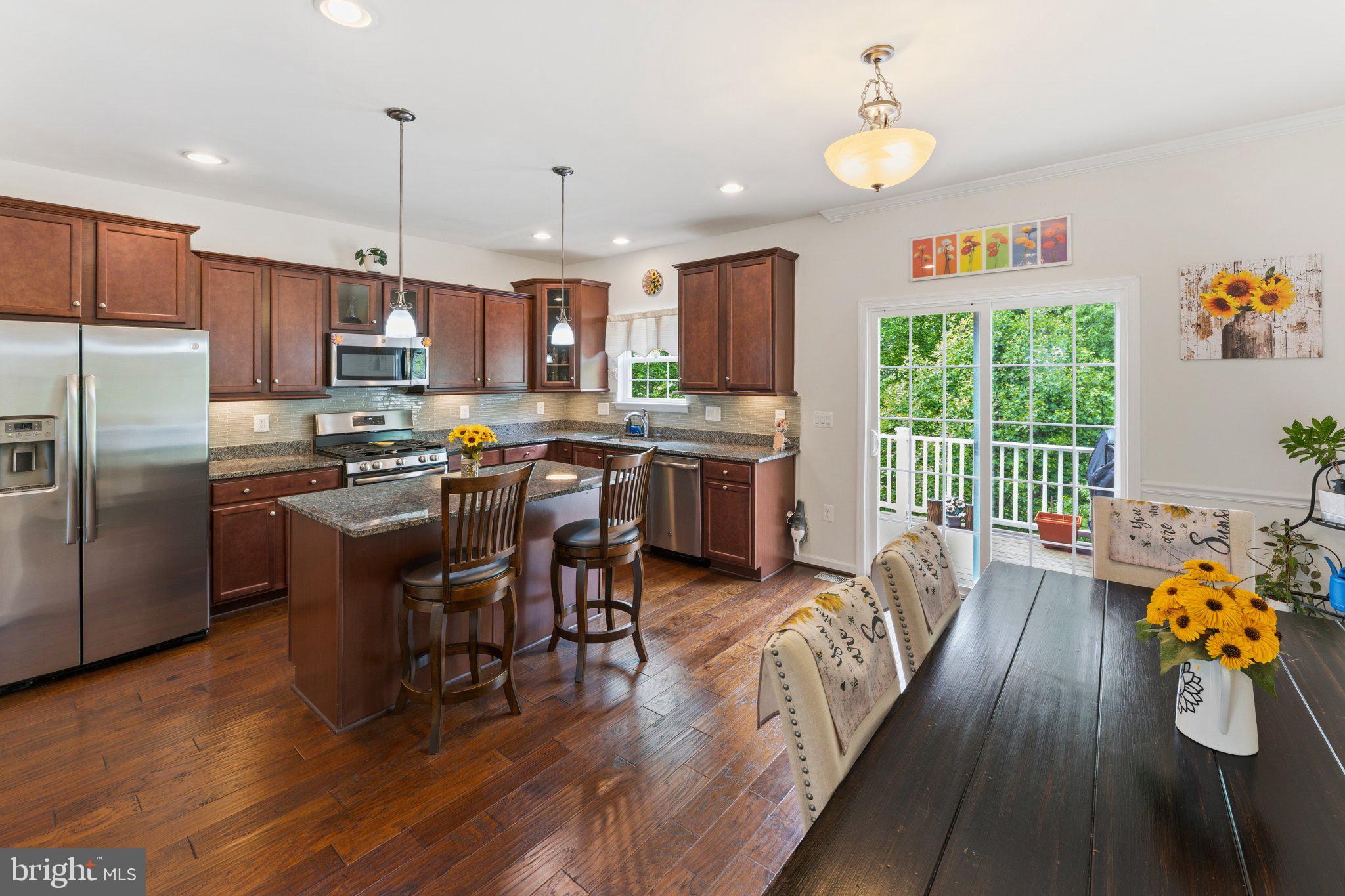 320 Tree Line Drive Fredericksburg, VA 22405 - Photo 21 of 49 a kitchen with stainless steel appliances a dining table chairs stove refrigerator and cabinets