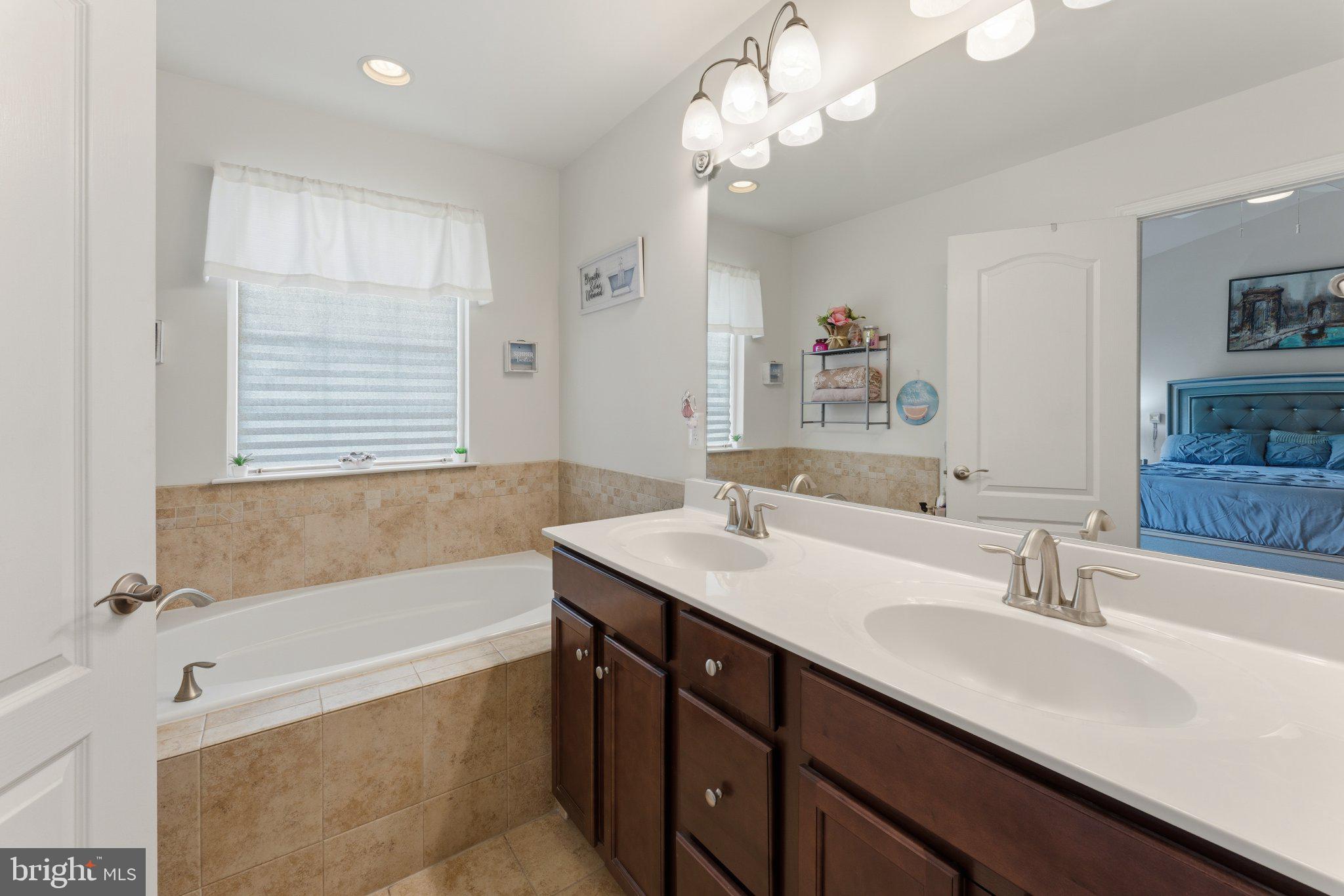 320 Tree Line Drive Fredericksburg, VA 22405 - Photo 31 of 49 a bathroom with a tub a double vanity sink and a mirror