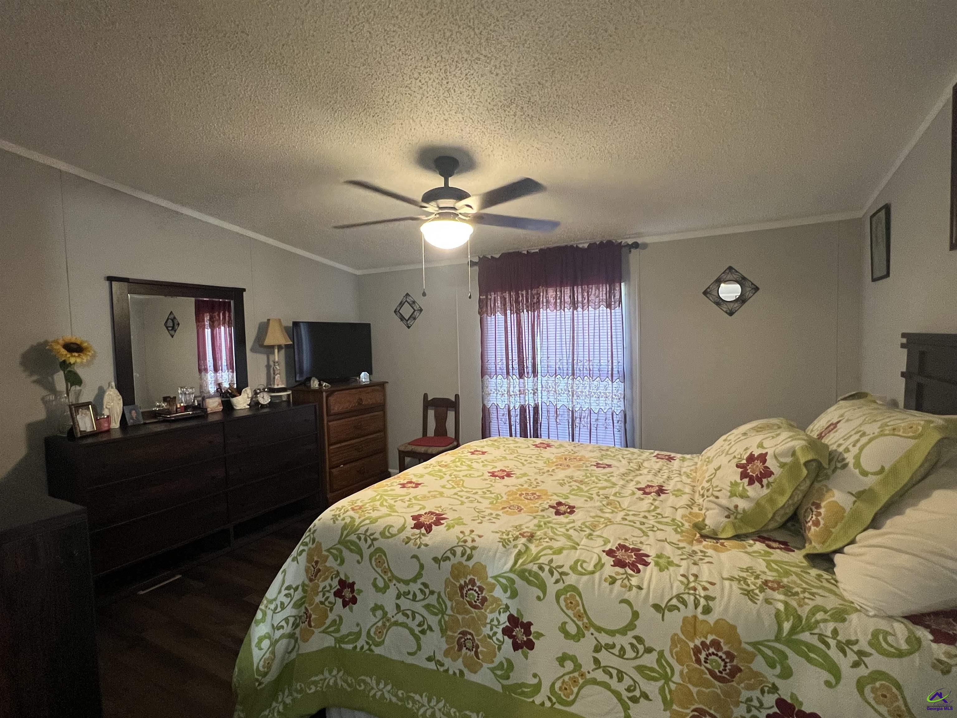 166 Pebble Hills Road Cochran, GA 31014 - Photo 20 of 27 a bed sitting in a bedroom and a chandelier