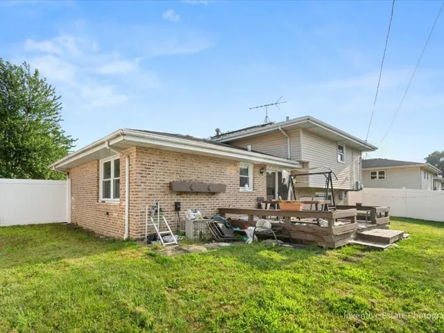 a big white house with a big yard and large trees with wooden fence