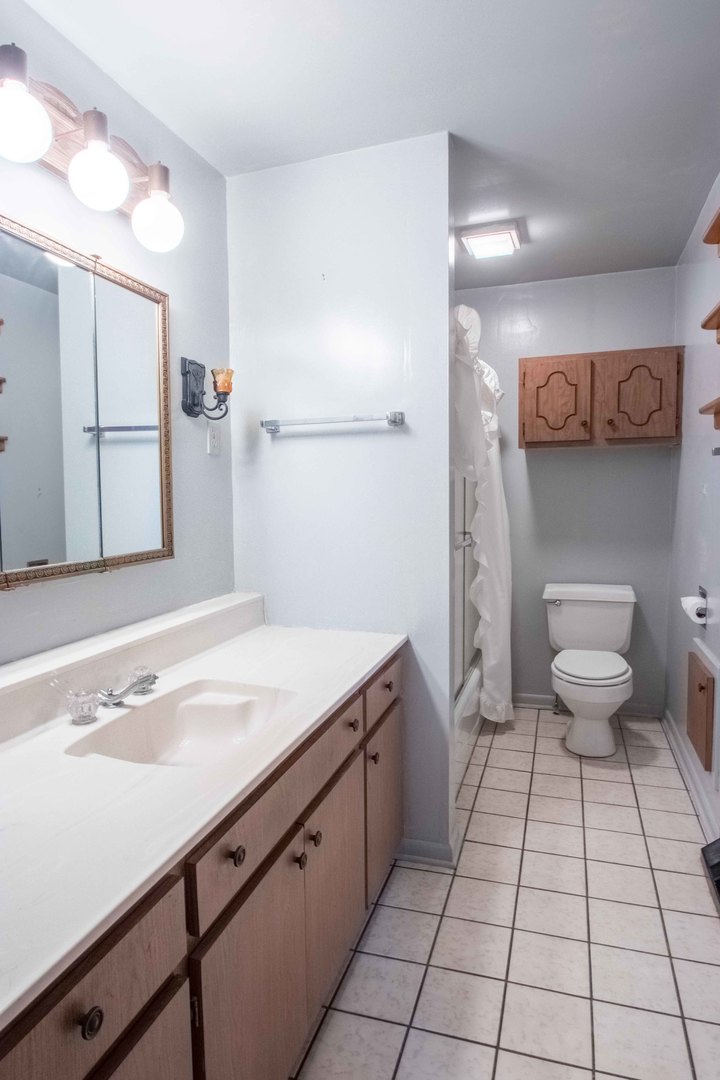 215 Clark Street Georgetown, IL 61846 - Photo 10 of 24 a bathroom with a sink a toilet and mirror