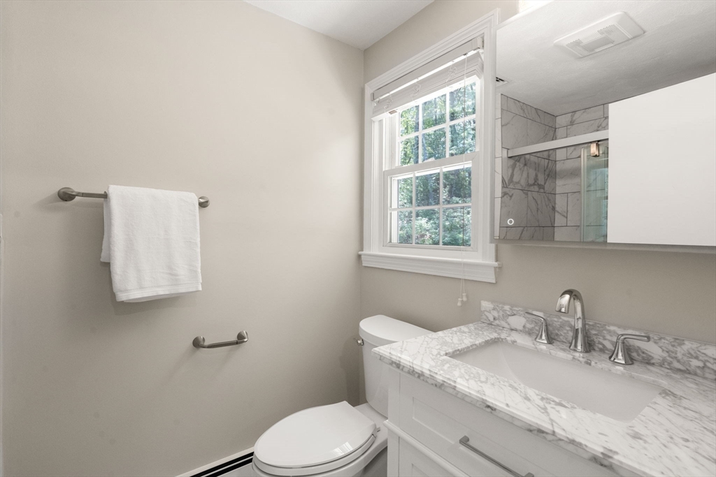 98 Union Street Norfolk, MA 02056 - Photo 26 of 38 a bathroom with a granite countertop toilet a sink and mirror