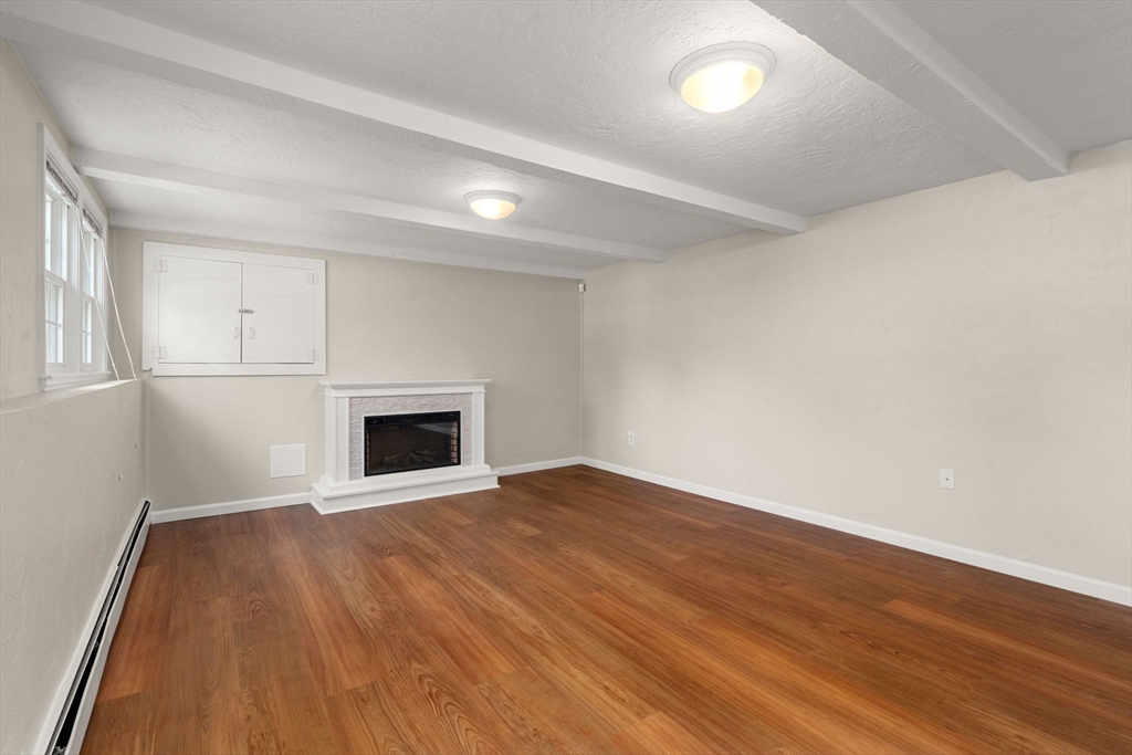 98 Union Street Norfolk, MA 02056 - Photo 31 of 38 an empty room with wooden floor and fireplace