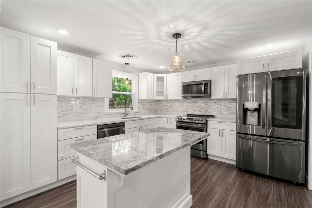 98 Union Street Norfolk, MA 02056 - Photo 10 of 38 a kitchen with kitchen island granite countertop stainless steel appliances a counter space and wooden floor