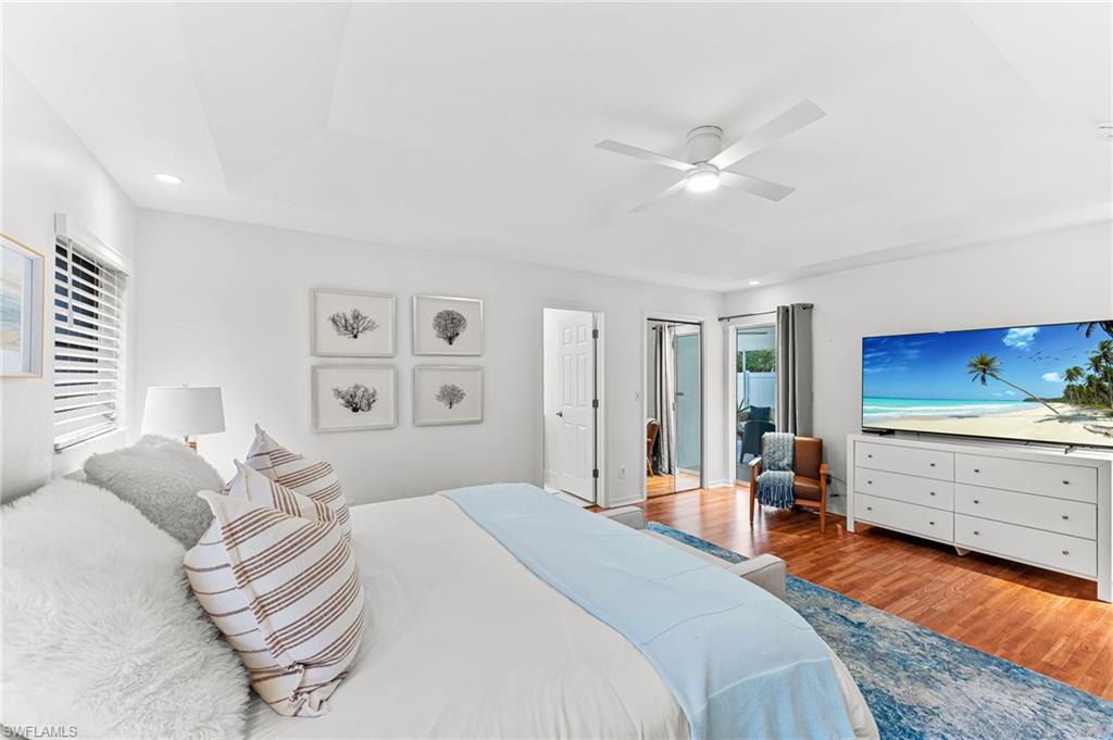 690 100th Avenue North Naples, FL 34108 - Photo 15 of 33 a bedroom with a bed and a chandelier