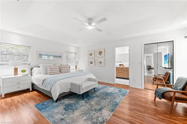 a spacious bedroom with a bed and wooden floor