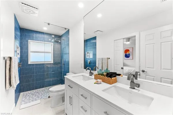 a bathroom with a sink a toilet and shower