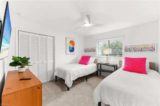 a bedroom with two beds and potted plant