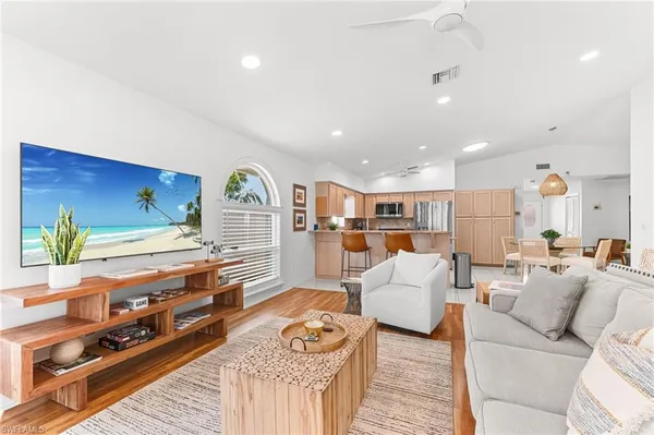 a living room with furniture a rug and kitchen view