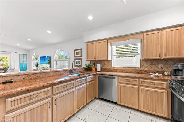 a kitchen with cabinets appliances a sink and a window
