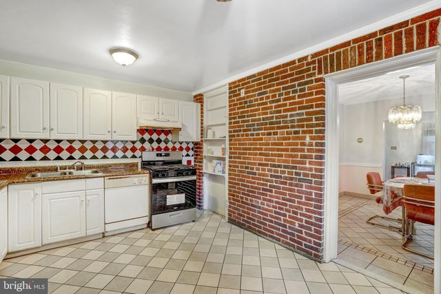 a kitchen with white cabinets and refrigerator