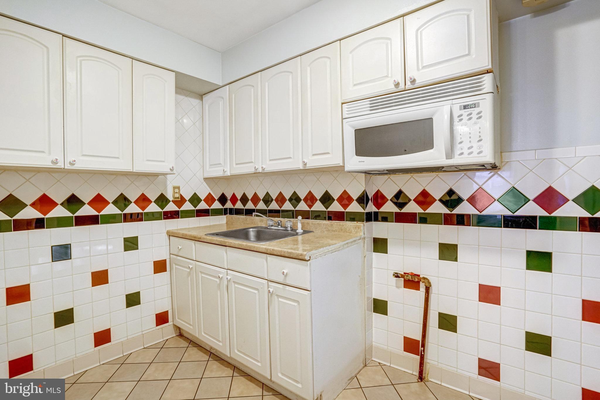 102 South Glebe Road Arlington, VA 22204 - Photo 14 of 52 a kitchen with white cabinets and sink