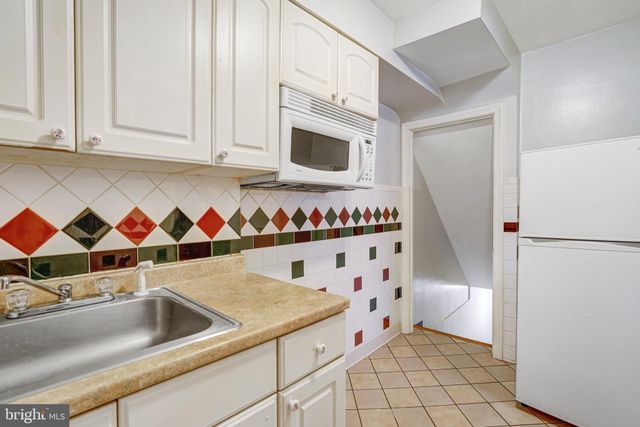 a kitchen with granite countertop white cabinets and stainless steel appliances