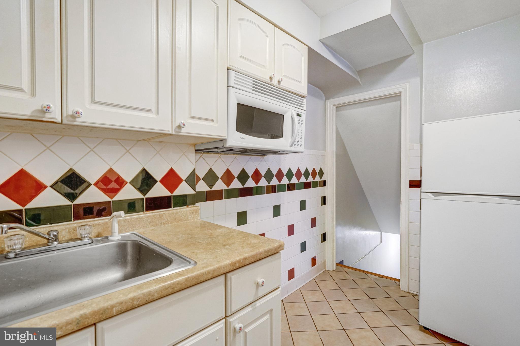 102 South Glebe Road Arlington, VA 22204 - Photo 15 of 52 a kitchen with white cabinets and refrigerator