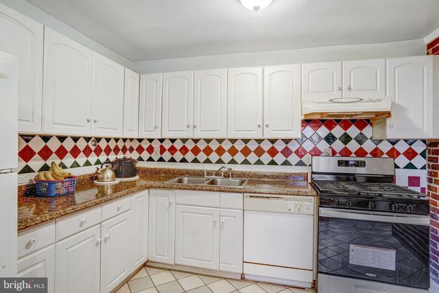 a kitchen with granite countertop a sink and a refrigerator