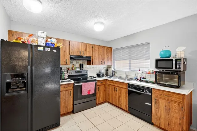 a kitchen with stainless steel appliances granite countertop a refrigerator sink and stove