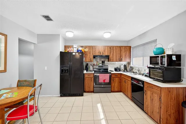 a kitchen with stainless steel appliances granite countertop a refrigerator and a stove top oven