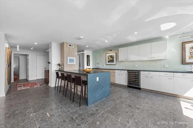a large kitchen with kitchen island a sink table and chairs