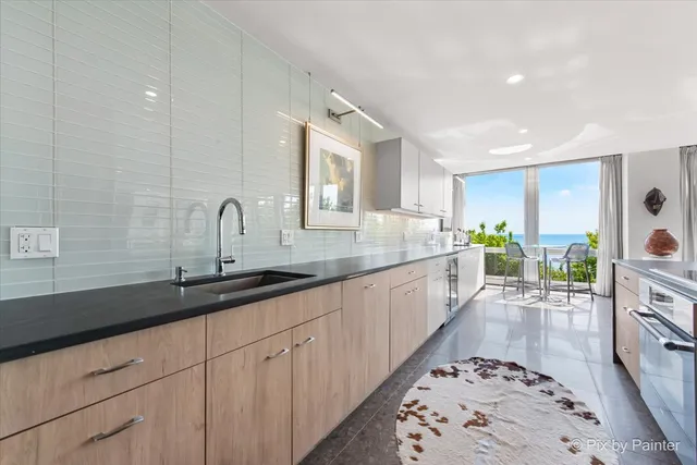 a large white kitchen with a sink and cabinets