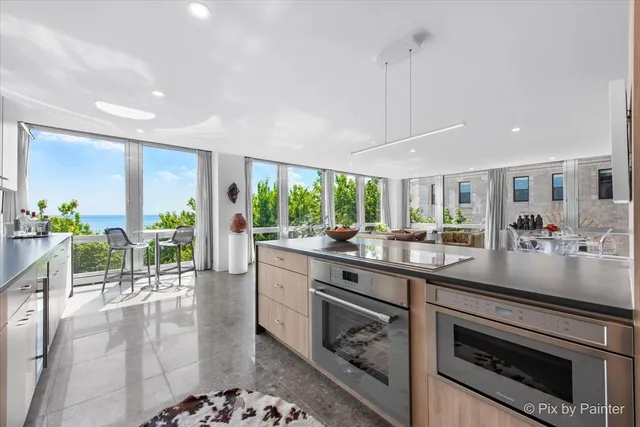 a kitchen with stainless steel appliances kitchen island granite countertop a stove a sink and a wooden cabinets