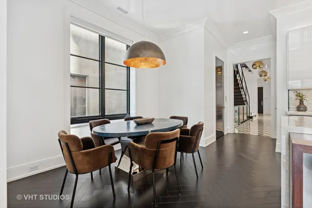 a kitchen with stainless steel appliances granite countertop a table chairs sink and cabinets
